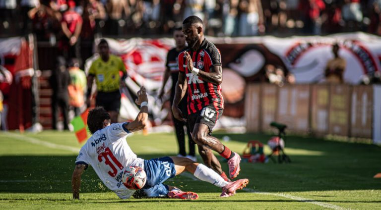 Roman Gómez, do Bahia, está dando carrinho na bola disputada por Ramon, do Vitória, em pé