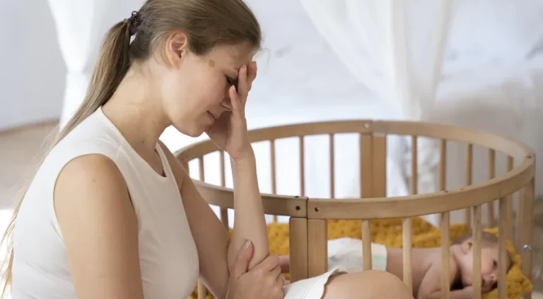 close-up-tired-mom-taking-care-newborn-baby
