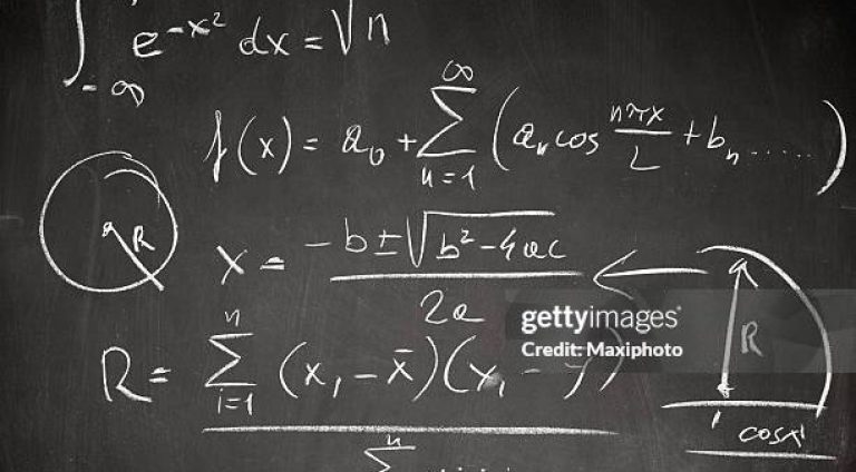Complicated math formula written on a blackboard with white chalk