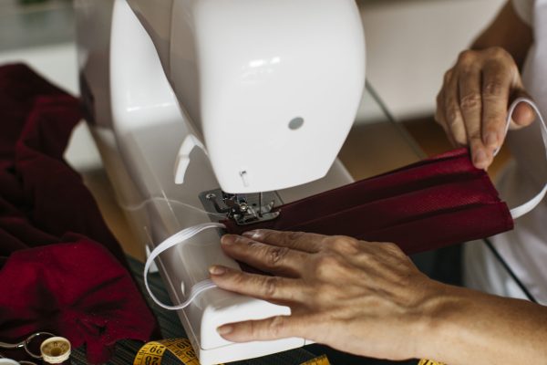 Hands of a woman sewing face masks
