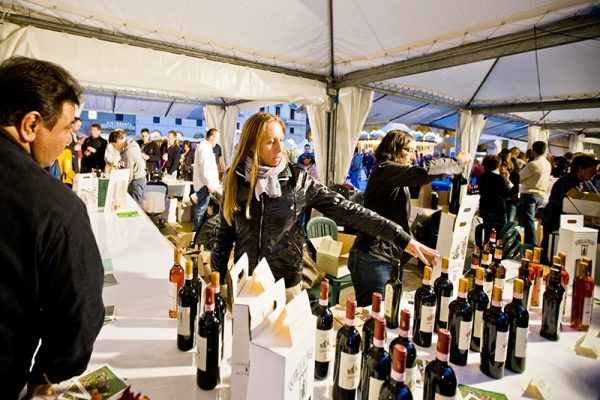 Florence, Italy - October 7, 2011: Outdoor Wine and Food Fair "Emozioni dal Chianti", Florence, Italy. Regular Food and Wine Festival taking place in Florence, demonstrating wines and food from few municipalities of Toscana. Shot made at the evening at Piazza Repubblica. People visiting event to taste and buy food and wine.