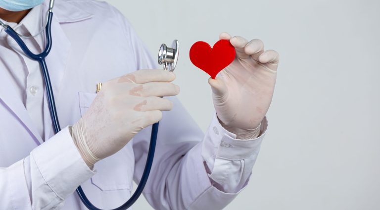 World diabetes day;docter holding stethoscope and red heart wooden shape